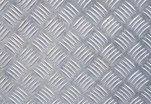 Silver metal panel with checkered crosshatch pattern. Background and wallpaper texture
