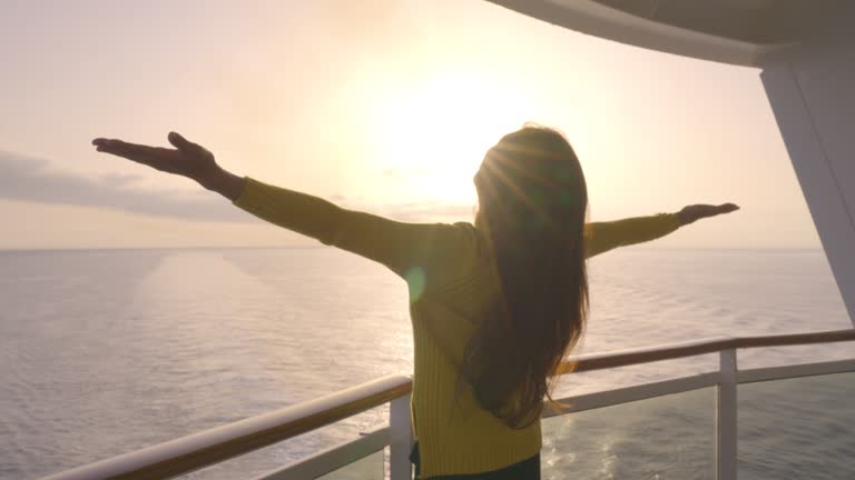 In silhouette of cruise luxury travel woman excited of sunset on private balcony deck.