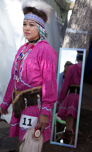 Santa Fe, NM, USA: A young participant at the 2022 annual outdoor Santa Fe Indian Market fashion show. The market is spread out around the historic Santa Fe Plaza, showcasing North American Indigenous arts and culture. Hundreds of artists from around the U.S. participate in the two-day event, with visitors numbering about 100,000.