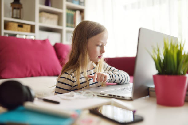 istock Young schoolgirl doing her homework with digital tablet at home. Child using gadgets to study. Education and distance learning for kids. Homeschooling during quarantine. 1464637217