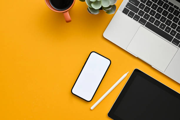 istock Top view of a creative office desk workspace with smartphone mockup on yellow background. 1464640199