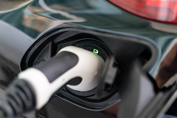 istock Plugged cable charging an electric car at home. 1464642336