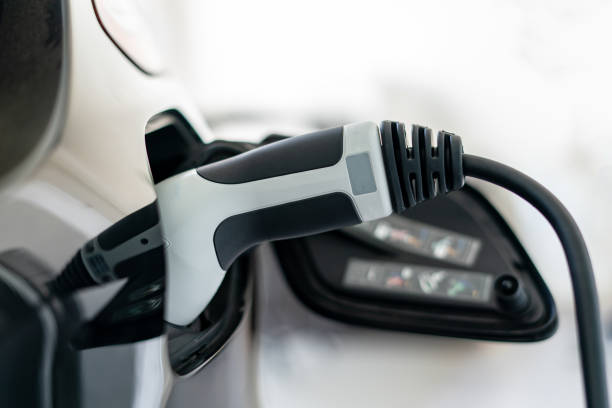 istock Plugged cable charging an electric car at home. 1464643090