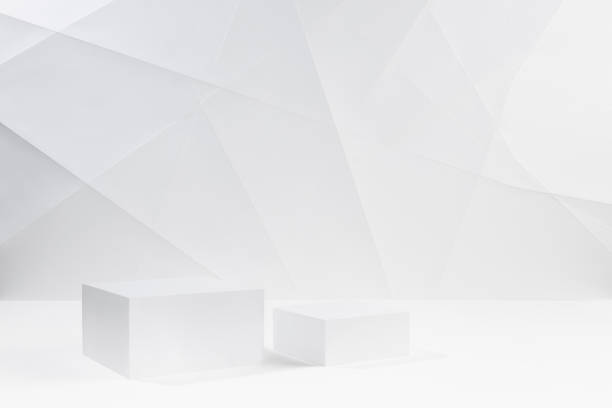 istock Two elegant white square podiums mockup on white table in soft light white interior with lines, angles in geometric modern style for presentation cosmetic products, goods, branding, design. 1464646500