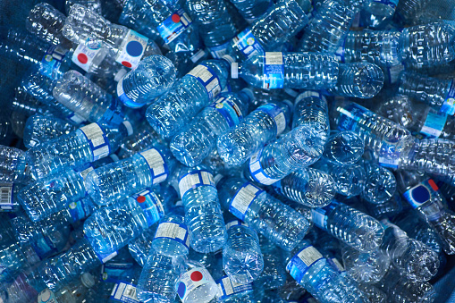 Close-up of a collection of plastic water bottles sitting in a pile in a recycling center