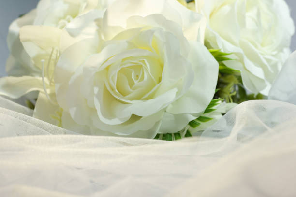 istock Fake white rose bouquet, tulle on table, rose fabric texture, artificial rose bouquet, romatic, valentine, wedding flower. copy space. 1464656414