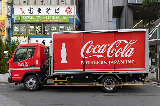 Lake Oswego, OR, USA - Apr 12, 2021: A Coca-Cola delivery driver unloads his truck outside of a Domino's Pizza restaurant in Lake Oswego, Oregon.