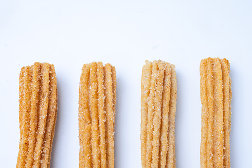 Churros line up on a white table.
