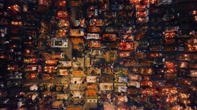 Aerial view above a illuminated and decorated cemetery, during Dia de Muertos, in Mexico city - cenital, drone shot