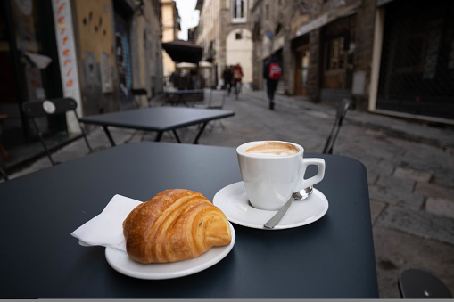 True Italian breakfast, Cappuccino coffee and a brioche on the street. High quality photo