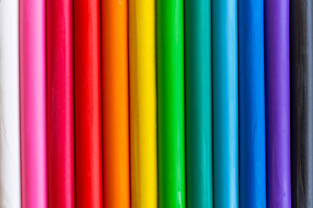 Multicolored pieces of plasticine are arranged vertically as a background.