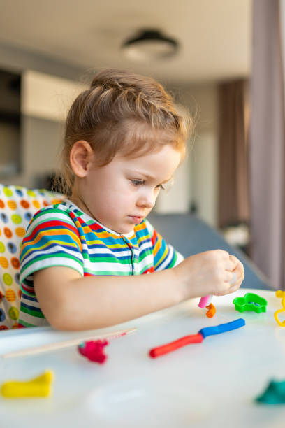 istock Little girl plays with multi-colored plasticine, creates different shapes 1464666953