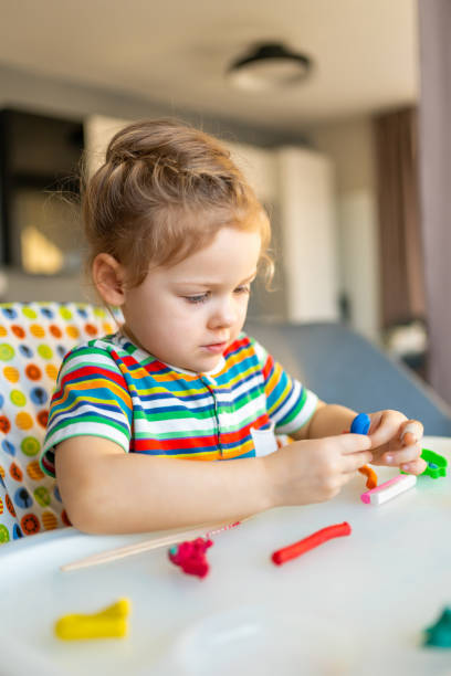 istock Little girl plays with multi-colored plasticine, creates different shapes 1464666959