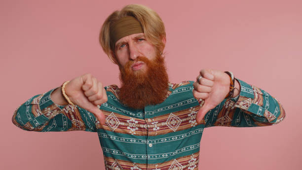 istock Upset hippie man in pattern shirt showing thumbs down sign gesture, disapproval dissatisfied dislike 1464667131