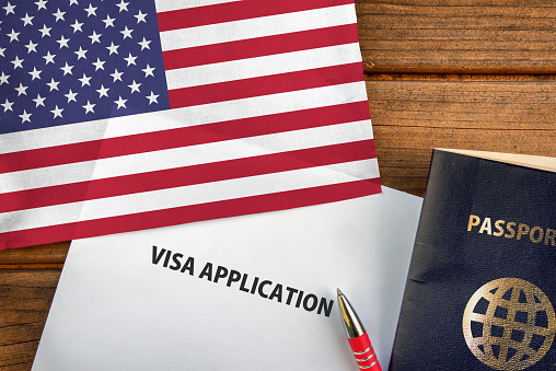 Visa application form, passport and flag of United States