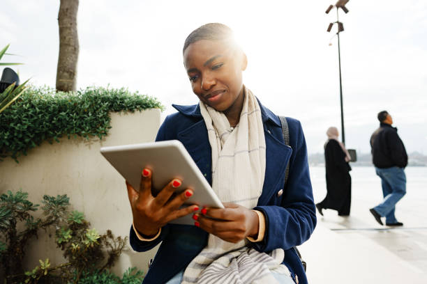 istock Black happy woman using a digital tablet outdoors 1464673003