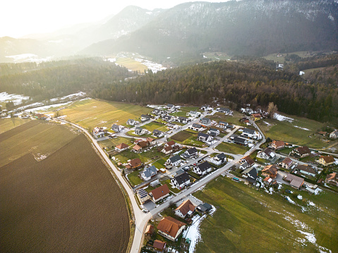 Aerial view of a new neighborhood located in Europe, Slovenia. Modern houses with large green yards and solar panels on the roof. Shot at sunset.