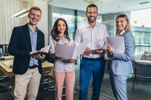 istock Group of young business people working together while standing in creative office 1464682799