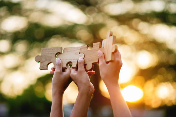 istock jigsaw and hands Combine the power 1464682804