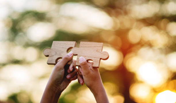 istock jigsaw and hands Combine the power 1464682807