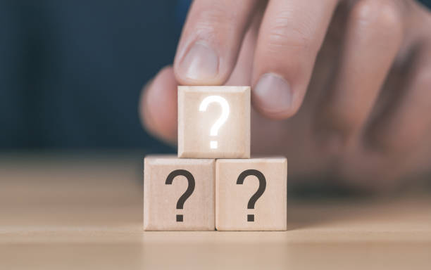 istock Businessman holding a wooden block showing a question mark 1464685568