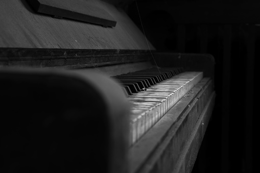 A closeup of an old dirty piano. Black and white