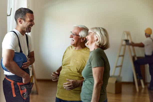 istock Happy senior couple talking to manual worker during renovation process at home. 1464688961