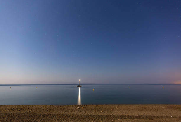 istock Beautiful view of a boat with light reflected on a tranquil sea 1464692120