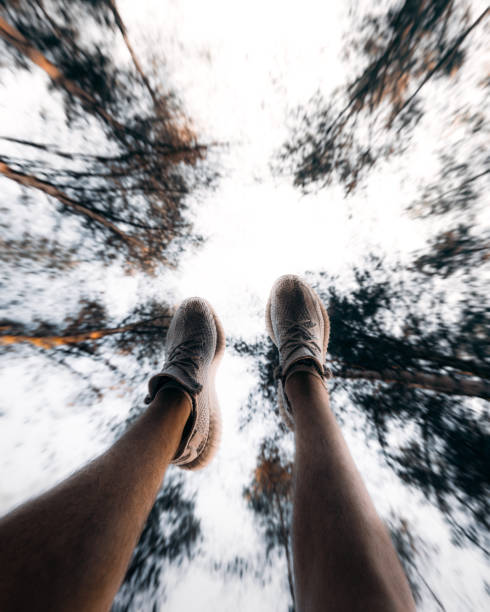istock Person's feet in the air in a forest under the sunlight with a blurred background 1464692538