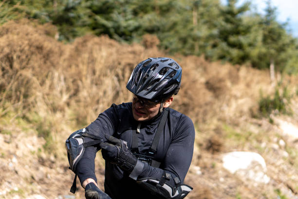 istock Young mountain biker putting on his protective gear 1464693087
