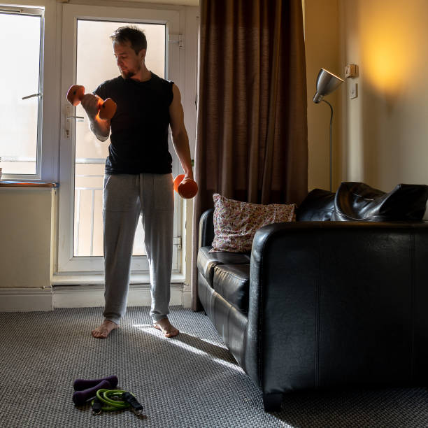 istock Young Caucasian man doing weight lifting at home 1464693267