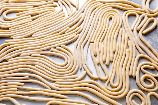a tray of hand rolled pci pasta made from sratch