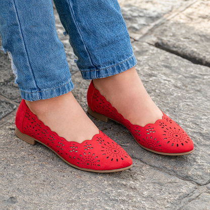 A closeup of a person wearing casual stylish and comfortable red flat shoes