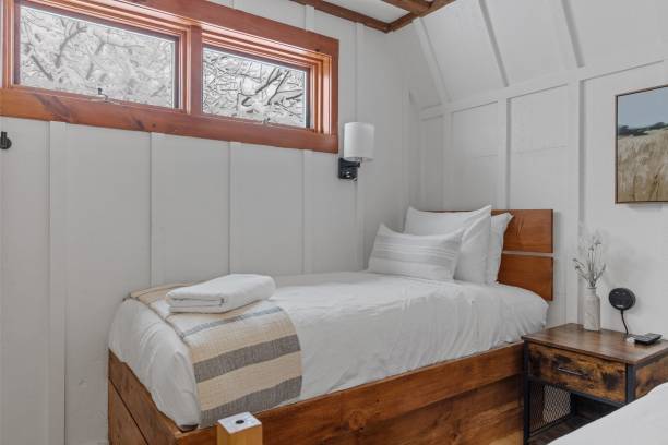 istock Small comfortable simple bedroom with one bed and white walls 1464693976