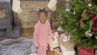 istock Black toddler placing gift under Christmas tree 1464694072