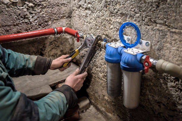 Plumber installing water equipment - meter, filter and pressure reducer stock photo