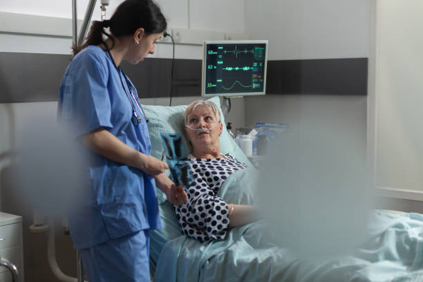 пожилой пациент в радиологической больничной палате, лежащий в постели - medical oxygen equipment healthcare and medicine 70s mature adult стоковые фото и изображения
