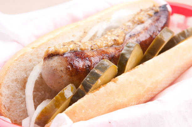 Two tasty hotdogs served on a recyclable paper, on a wooden home, bar or restaurant table, a close up image with a copy space