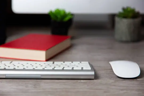 A selective focus shot of a keyboard and a mouse of Apple iMac computer