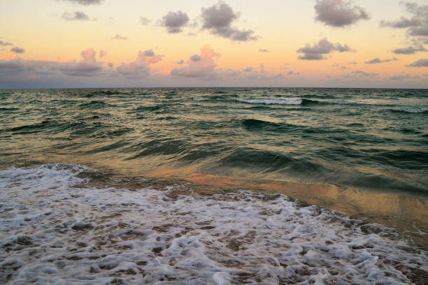 A scenic view of a rough sea under a sunset sky