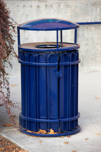 istock Vertical shot of a blue trash can outdoors 1464697521