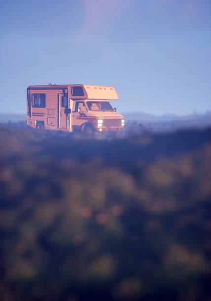 istock Camper with lit headlights in foggy countryside. 3D render. 1464698050
