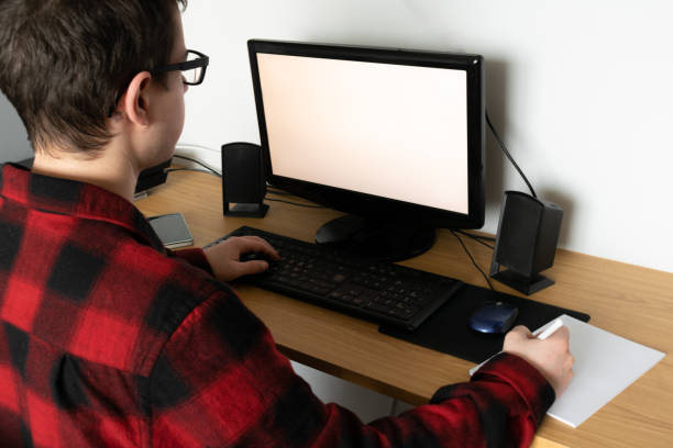 istock Spanish Caucasian teenager in an online class with his computer and taking notes, indoors 1464698585