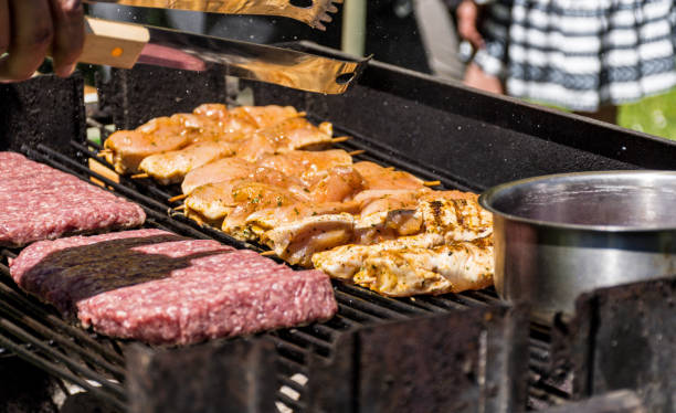 istock Close-up image of man preparing meat on grill in back yard. 1464700277