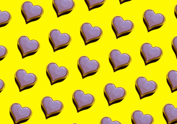 A yellow background with a heart-shaped milk chocolate bonbons pattern. International chocolate day
