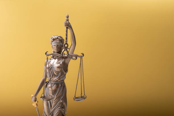 istock Sculpture of justice on a yellow background 1464704368
