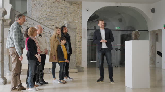 Confident Caucasian Museum Curator Giving A Presentation Of The Current Exhibition In A Museum