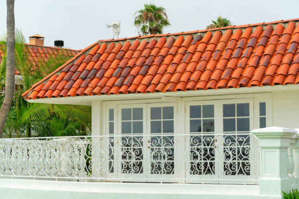 A modern house with tile roofs and glass walls under a white sky