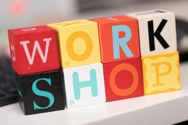 A closeup shot of cubes saying "work shop"  with blurred background