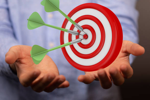 istock 3d rendering of a target board with arrows hovering over human hands 1464705634